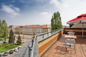 乔左维尔考普尔斯基波兰地区戈茹夫区布酒店的一个带椅子和遮阳伞的阳台,以及一座建筑