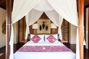 塔巴南瓦卡甘伽酒店的卧室配有一张带白色窗帘的大床