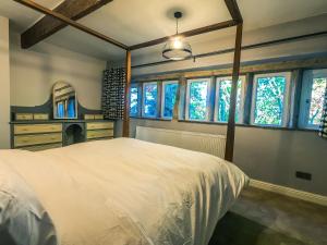 奥尔德姆Luxury traditional stone farmhouse in Saddleworth的卧室设有白色大床和窗户。