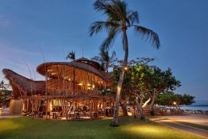 努沙杜瓦巴厘岛努沙杜阿海滩Spa酒店的棕榈树草屋顶的建筑