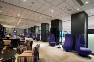 古尔冈古尔冈凯悦酒店的一间设有紫色椅子和桌子的等候室