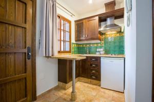 阿洛拉Hostal Don Joaquín Alora的厨房配有木制橱柜和白色冰箱。