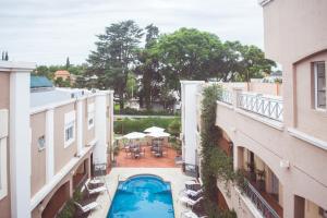 上格拉西亚Solares Hotel & Spa的两栋建筑之间庭院中游泳池的顶部景色