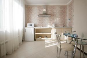 莫斯科弗拉德基诺公寓式酒店的一间带桌子和冰箱的小厨房