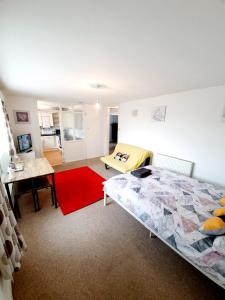 雷利Rayleigh Town Centre 2 Bedroom Apartment的一间卧室配有一张床和红色地毯