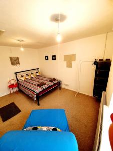 雷利Rayleigh Town Centre 2 Bedroom Apartment的一间卧室配有一张床和一张蓝色的沙发