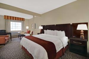 休斯顿Baymont by Wyndham Houston/Westchase的酒店客房带一张大床和一把椅子