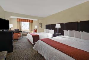 休斯顿Baymont by Wyndham Houston/Westchase的酒店客房设有两张床和一台平面电视。