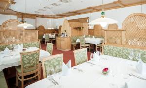 霍赫斯特代林德酒店的一间设有白色桌椅的用餐室