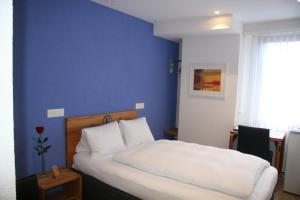 阿尔勒斯海姆艾尔米塔什酒店的卧室配有白色的床和蓝色的墙壁
