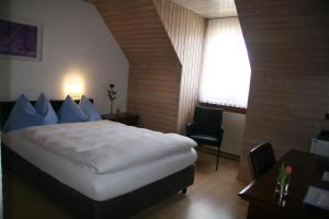 阿尔勒斯海姆艾尔米塔什酒店的一间卧室配有一张床、一张书桌和一个窗户。