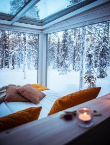 阿卡斯洛姆波罗Arctic Skylight Lodge的卧室设有窗户,享有雪覆盖的树木美景