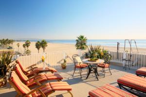 洛杉矶威尼斯套房酒店的一个带桌椅的庭院和海滩
