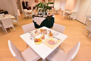 Pradamano乌迪内标准酒店的一张白色桌子,上面放着食物板