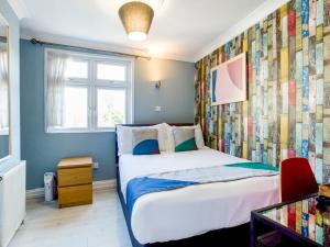 伦敦Sino Hotel的一间卧室设有一张床和色彩缤纷的墙壁