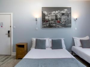 伦敦Sino Hotel的卧室配有两张床,墙上挂着一幅画