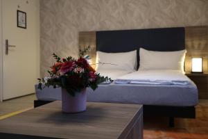 卢塞恩斯帕茨酒店的一间卧室,配有一张带花瓶的桌子