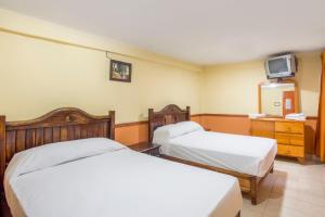 AcambayOYO Hotel San Agustin的一间酒店客房,设有两张床和电视