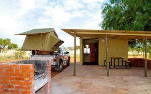 HardapKalahari Anib Campsite的停在一个帐篷棚下的卡车