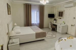 库尔斯克Отель "Даймонд Луговая"的一间卧室配有一张床、一个浴缸和一个水槽