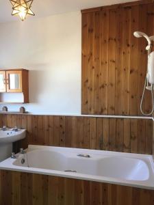 布里德灵顿Clifftop Apartment的带浴缸的浴室,设有木墙