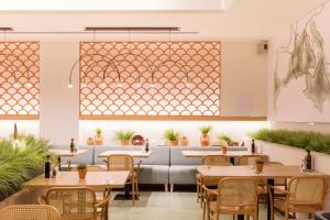 马略卡岛帕尔马Ars Magna Bleisure Hotel的餐厅设有桌椅和大窗户。