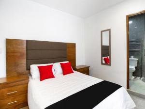 圣路易斯波托西Capital O San Jose, San Luis Potosi的一间卧室配有一张带红色枕头的大床