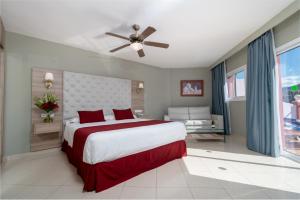 内尔哈洛斯阿科斯酒店的一间卧室配有一张大床和吊扇