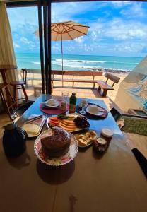 巴伊亚福尔莫萨SuRFCoRe House的一张带食物的桌子,享有海滩美景