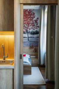 布达佩斯Lakeside Budapest Residences的一间带水槽的浴室和墙上的一幅树画