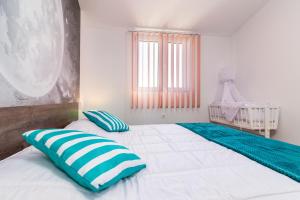 罗波里卡Selina Ferienwohnung的一间卧室配有两张带蓝白色枕头的床