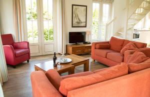 诺德韦克Bungalow 6p的客厅配有橙色沙发和电视