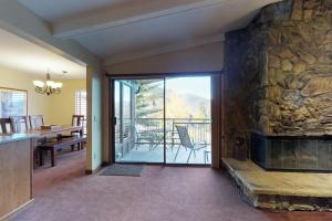 狄龙Lake Cliffe 302的一间带石头壁炉的客厅和一间用餐室