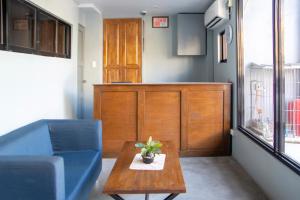 巴科洛德OYO 561 Abn Hostel的客厅配有蓝色的沙发和桌子