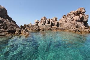 帕拉迪索海岸Costa Paradiso Resort的靠近岩石的水池