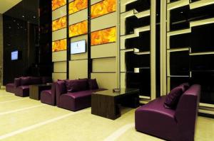 贵阳麗枫酒店·贵阳花果园购物中心店的客厅配有紫色沙发和桌子