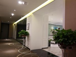 贵阳希岸·轻雅酒店贵阳花果园双子塔店的大堂种植了盆栽植物,墙壁白色