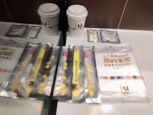 贵阳IU酒店·贵阳奥体中心华润万象汇店的一张桌子,上面放着一堆dvds和一些杯子