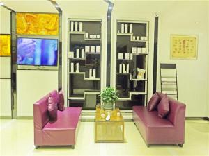 贵阳麗枫酒店·贵阳花果园财富广场店的客厅配有两把紫色椅子和一张桌子