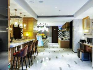 贵阳Magnotel guiyang fountain commercial center subway station hotel的大堂设有带凳子和柜台的酒吧