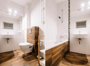 格丁尼亚Apartamenty Maestro的浴室设有卫生间和水槽,两幅图片