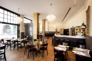 苏黎世苏黎世哥洛克恩霍福酒店的一间带桌椅的餐厅和一间酒吧