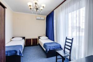 顿河畔罗斯托夫戏剧酒店的客房设有两张床、一把椅子和窗户。