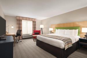 绍姆堡伊利诺伊州绍姆堡卡尔森江山套房酒店的酒店客房设有一张大床和一张书桌。