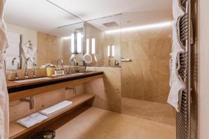 萨尔格米纳Auberge Saint Walfrid Hôtel Restaurant & Spa的一间带两个盥洗盆和淋浴的浴室
