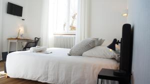 吕奥姆萨维尔酒店的一间卧室配有一张带白色床单的床和一扇窗户。