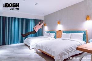 台南达煦23旅店的一个人在旅馆房间两张床之间跳跃