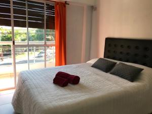 莫龙Cares Apartament, Morón, Buenos Aires的一张带两个枕头的床和一条毛巾