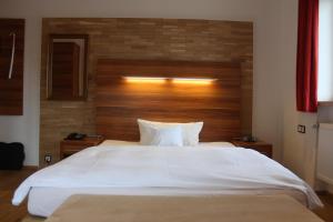 巴特莱辛哈尔艾姆拉奥斯酒店的卧室配有一张白色大床和木制床头板