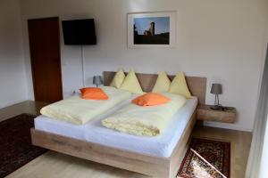 波斯特尔Gruberhof的一间卧室配有两张带橙色枕头的床